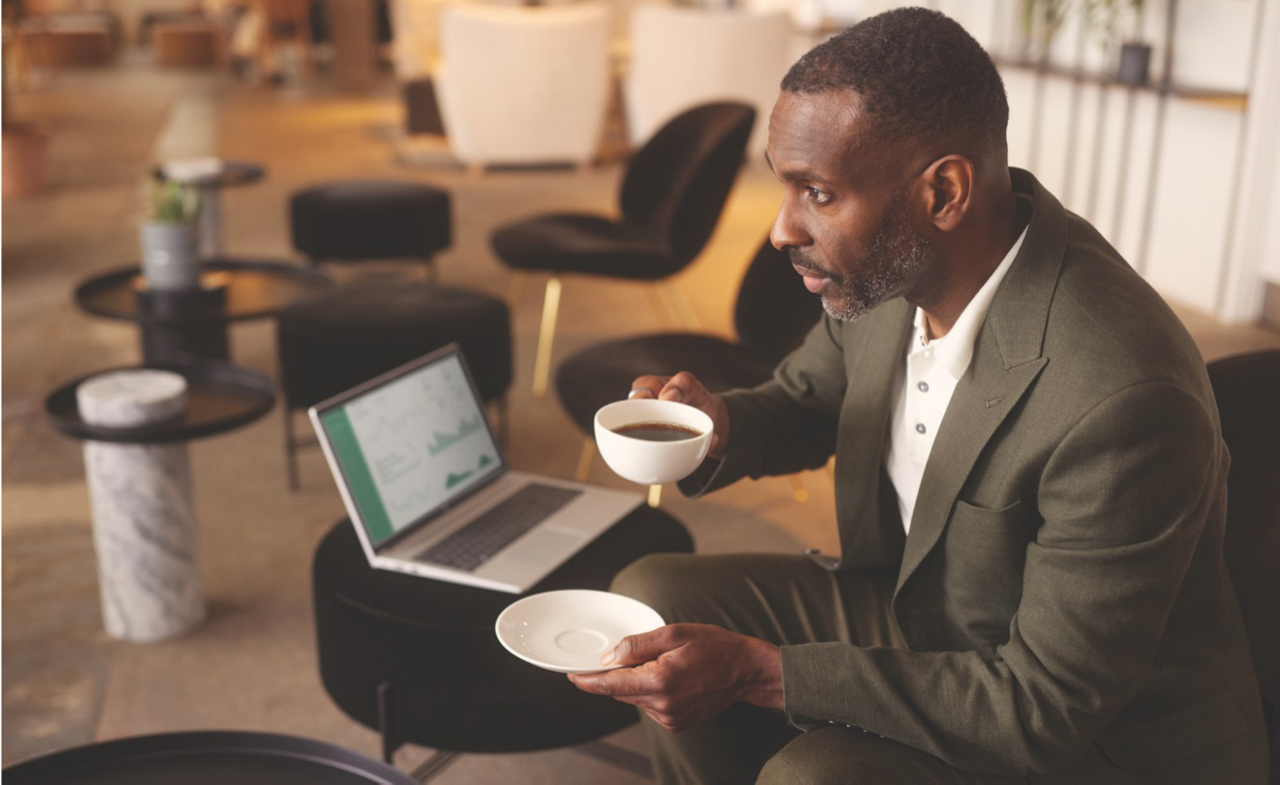 Image of a business man with a coffee and laptop