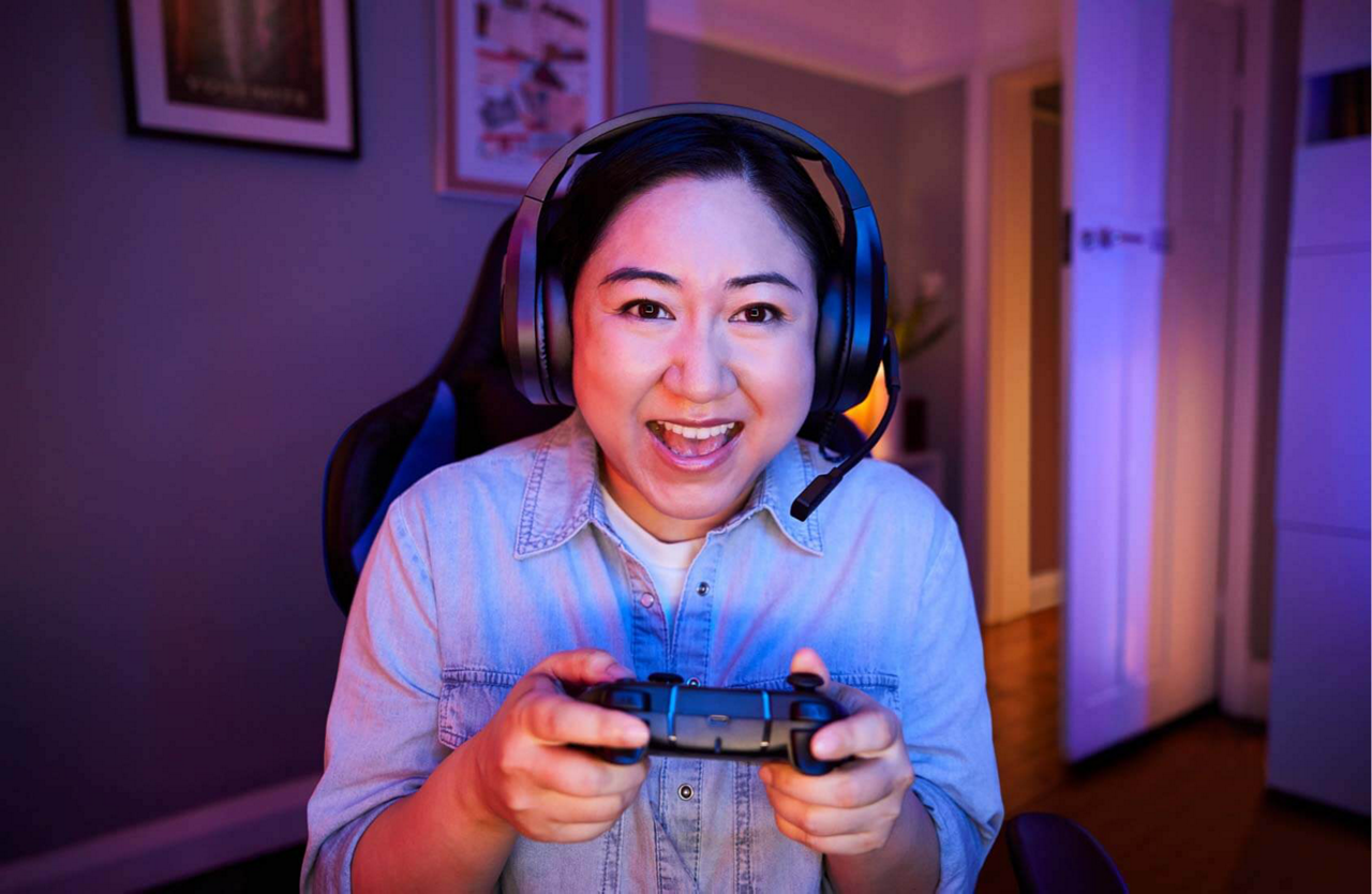 Person gaming wearing headset and holding a controller